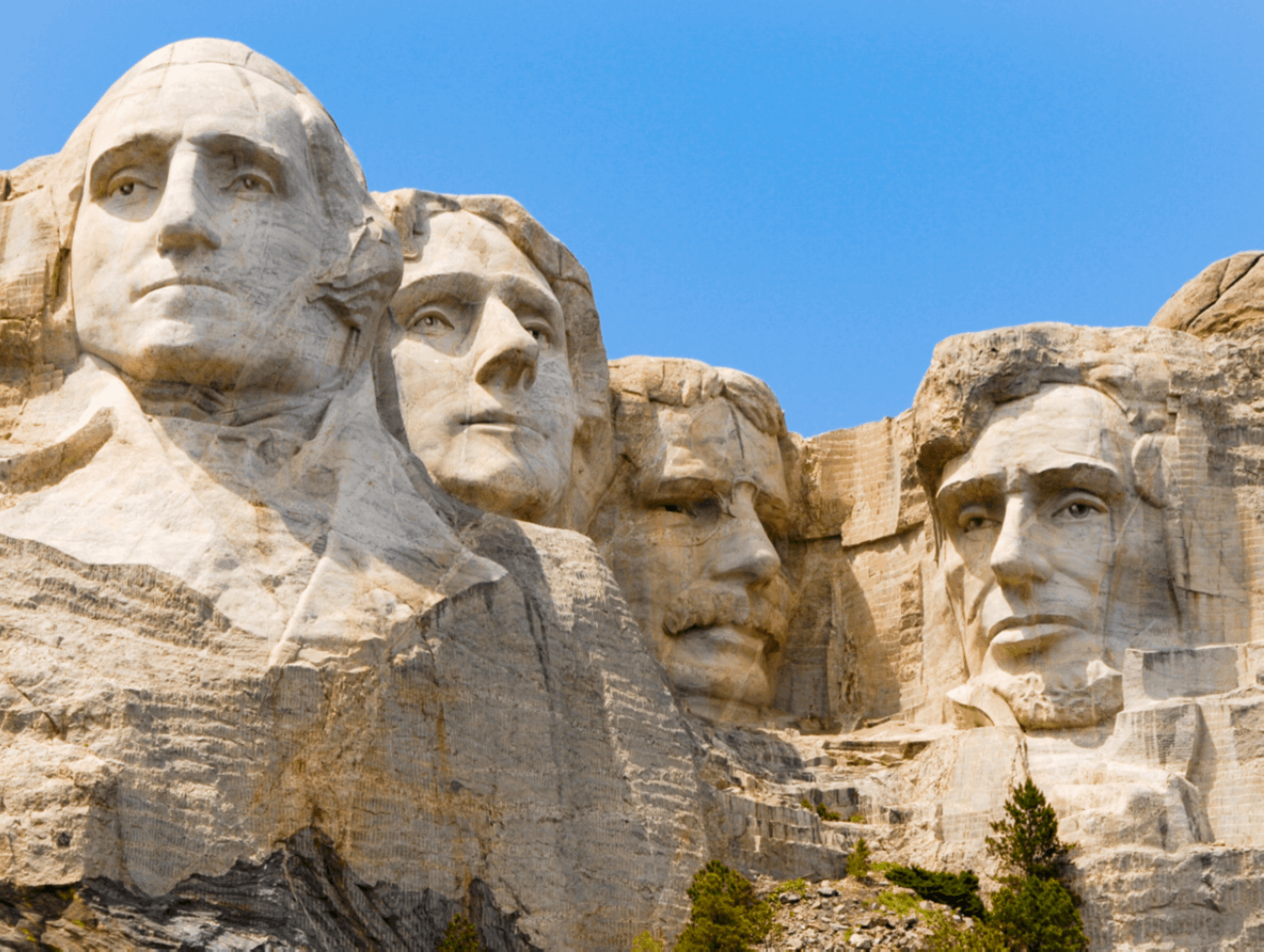 Mount Rushmore with the faces of the four presidents obscured by grey rectangles. This significant historical monument in the United States features sculptures of Presidents George Washington, Thomas Jefferson, Theodore Roosevelt, and Abraham Lincoln.