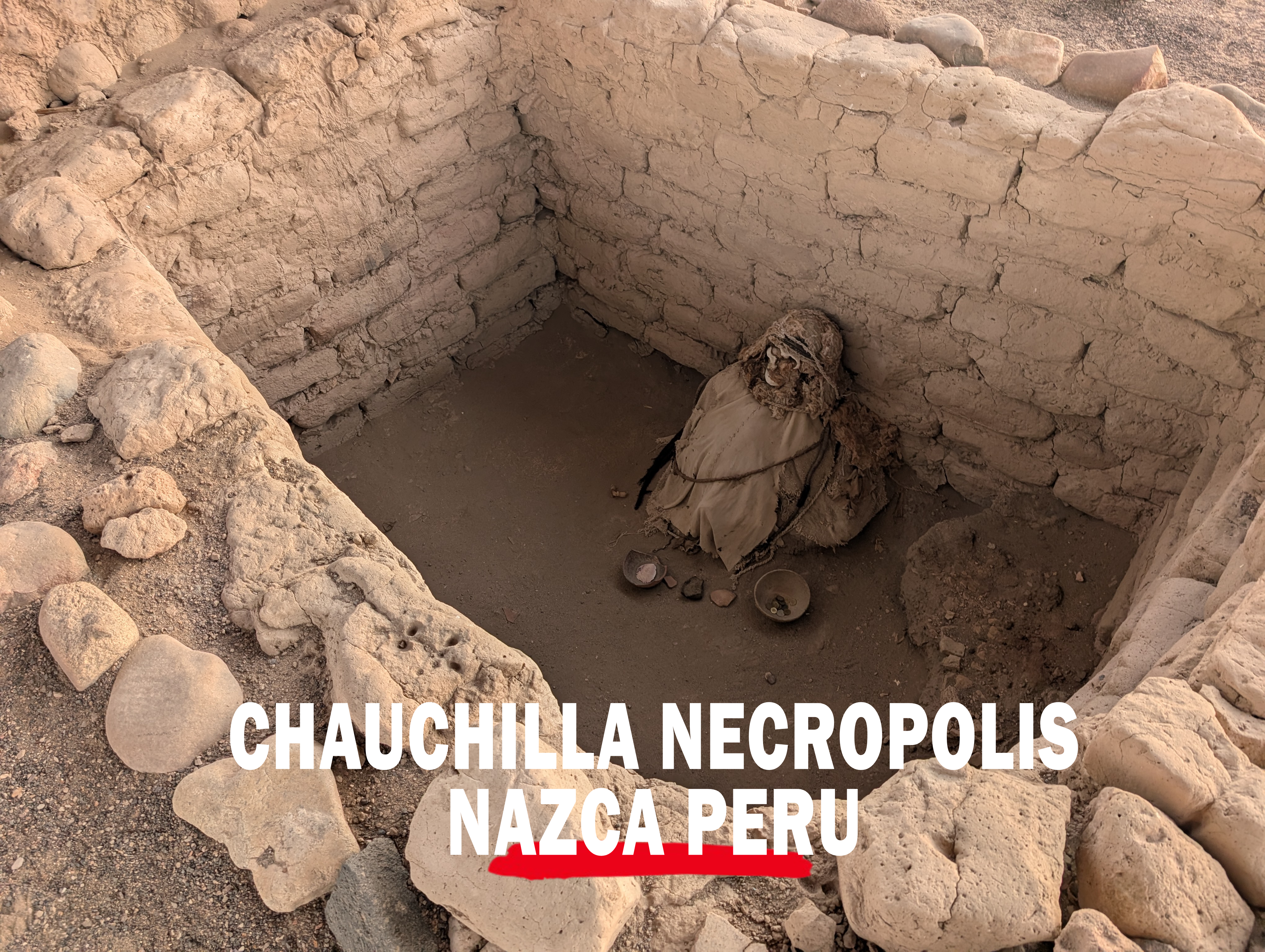 Mummified remains in an ancient burial chamber at Chauchilla Necropolis near Nazca, Peru, surrounded by Exploring Chauchilla Cemetery Peru: A Unique Experience adobe walls and desert stones.