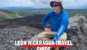 A traveler sits on a volcanic slope overlooking the landscape beneath the title “Leon Nicaragua Travel.”